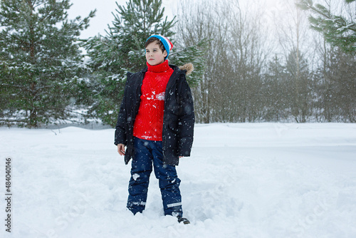 A cute teenage boy in a winter park