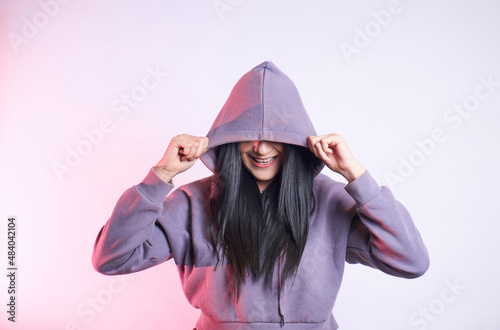 Anonymous positive woman covering eyes with hood photo