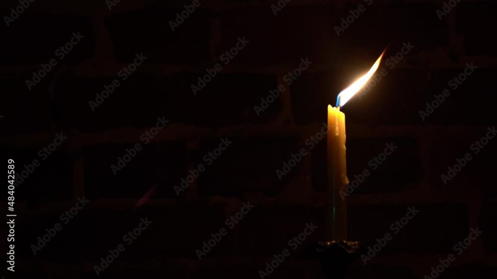 Candle flame closeup on a dark background. Melted Wax Candle light