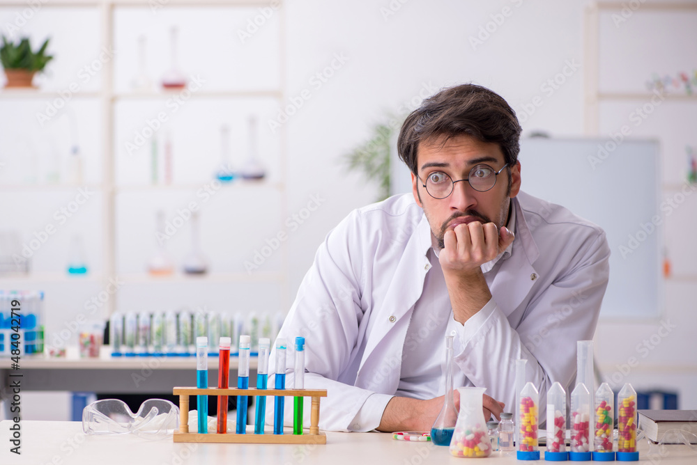 Young male chemist in drugs synthesis concept Young male chemist in drugs synthesis concept