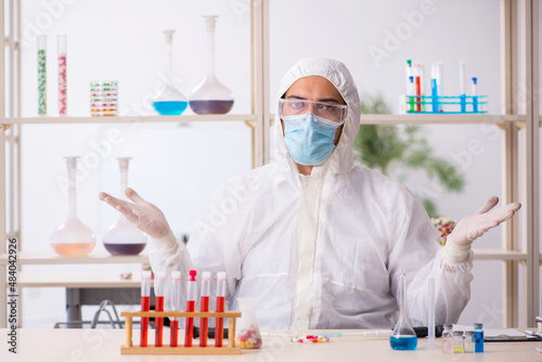 Young male chemist in drugs syntesis concept photo