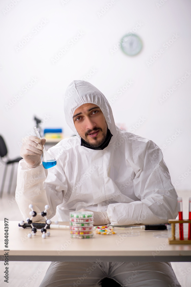 Young male chemist in drugs synthesis concept Young male chemist in drugs synthesis concept
