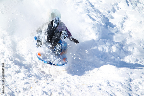 Kids having fun in the snow sliding © flysnow