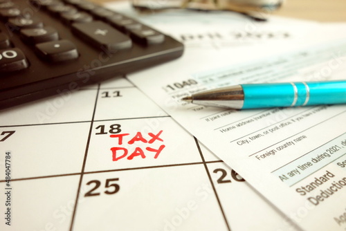 Tax payment day marked on a calendar - April 18, 2022 with 1040 form