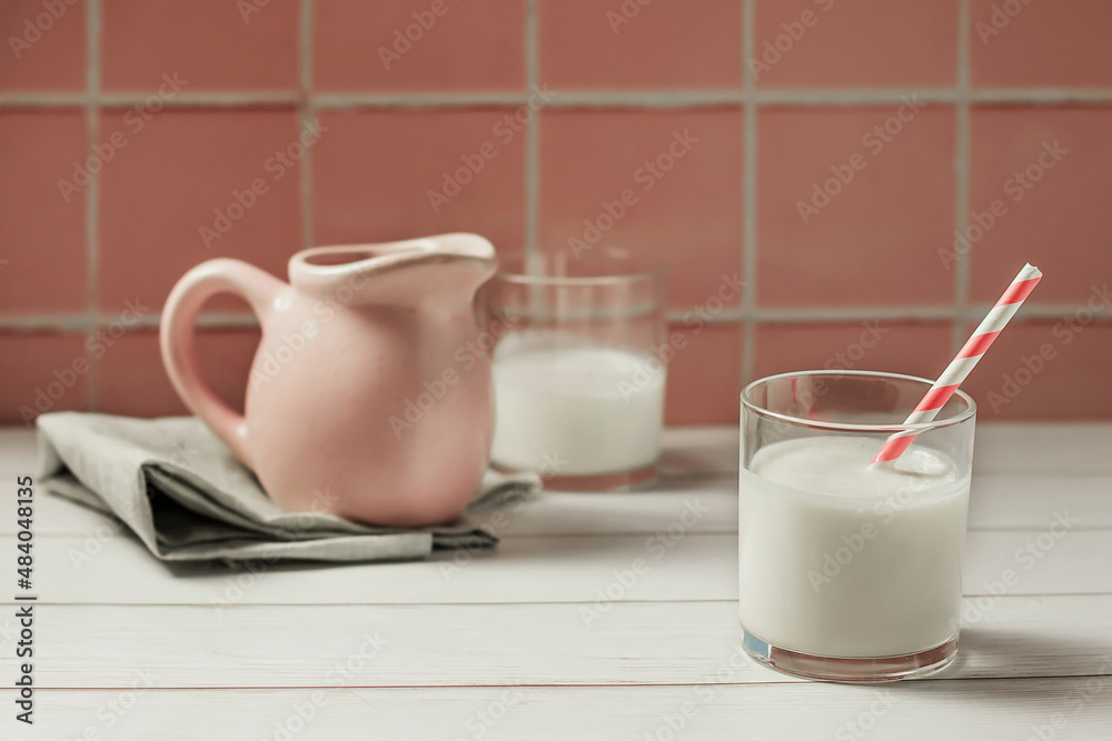 Banner of a glass of milk or yogurt and a jug of milk on a pink background. The concept of farm dairy products, dairy day. Space for copy. Banner of a glass of milk or yogurt and a jug of milk on a pink background. The concept of farm dairy products, dairy day. Space for copy.