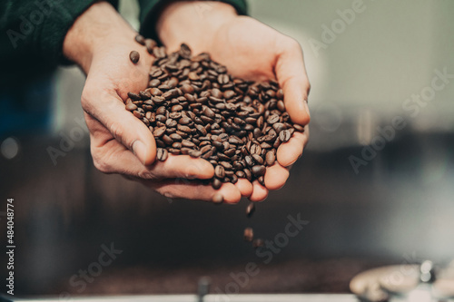 Dłonie wysypują ziarna kawy