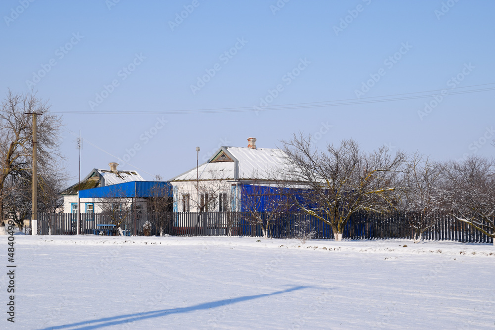 Village house in a Russian village in winter. house is in the snow.