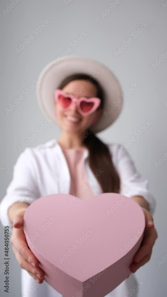Nice girl handing a pink gift box for valentine's day Nice girl handing a pink gift box for valentine's day