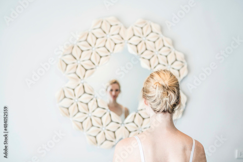 Frau blickt in Spiegel mit Muscheln photo