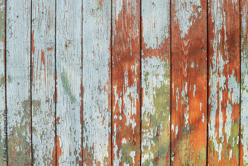 Light blue red and green weathered wooden background with cracked paint. © kyrychukvitaliy