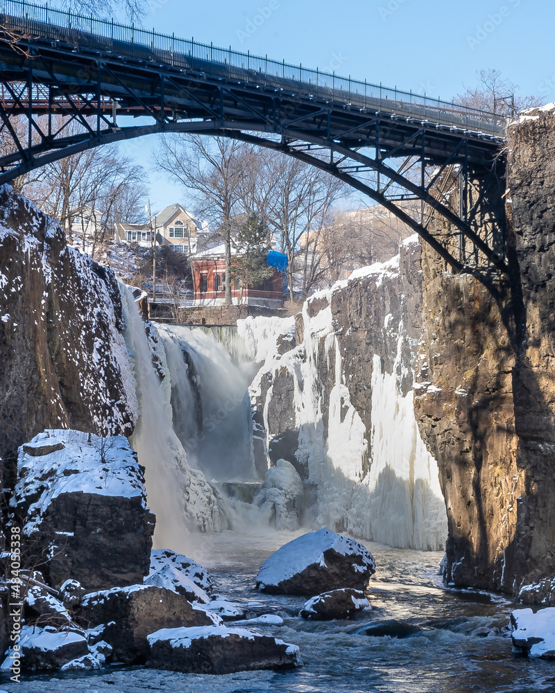 Paterson, NJ - USA - Jan 30, 2022 Vertical closeup view of the partially frozen falls at historic Paterson Great Falls National Historical Park during the winter.