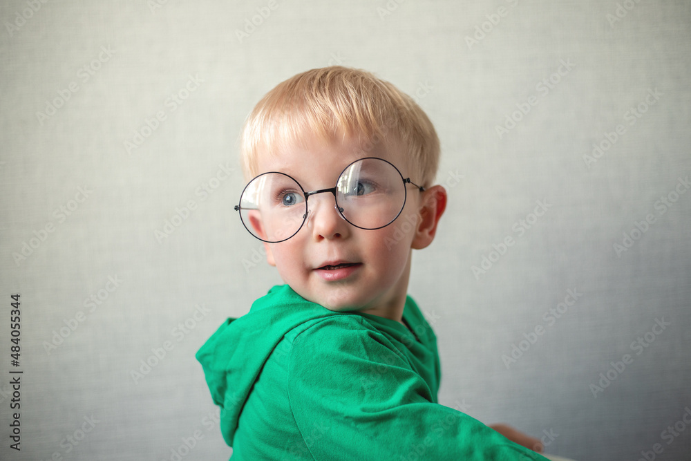portrait of a little boy in round glasses. boy looking at the camera and smiling portrait of a little boy in round glasses. boy looking at the camera and smiling
