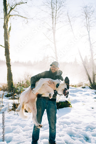 Cropped portrait of a man holding a squirming dog