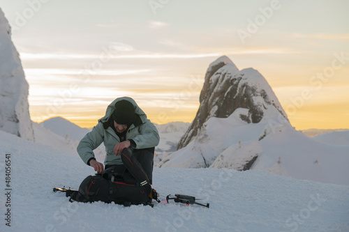 Drone Pilot launches a drone in frozen landscape photo
