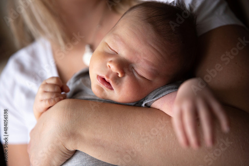 Sleeping baby in mother's arms photo