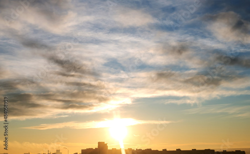 Morning sunrise over the city on a background of sky with clouds