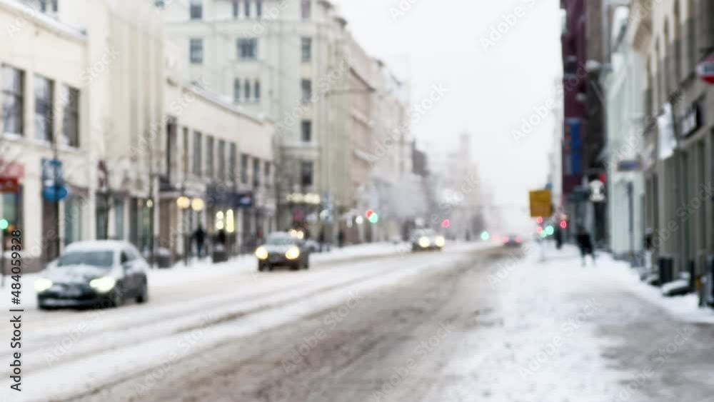 Defocused: City is busy with passing by cars and people during snowing winter Defocused: City is busy with passing by cars and people during snowing winter