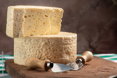 Fototapeta Naklejka Na Ścianę i Meble -  Semi-cured cheese from Brazil arranged on a rustic board on a green and white checkered tablecloth, selective focus.