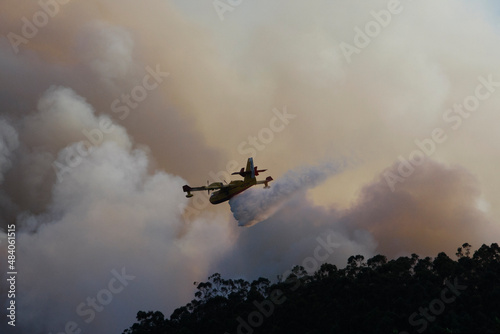 A Canadair CL-215 firefighting plane in the clouds of a forest fire