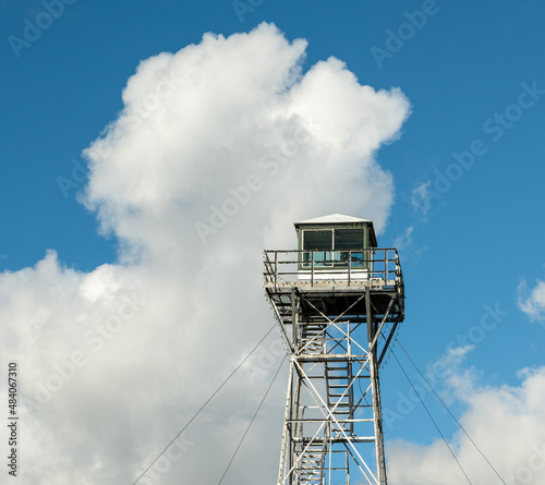 Wildfire lookout tower with big clouds on the background.