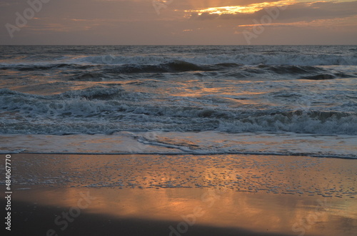 Esperanza de un nuevo amanecer en la playa contemplando las olas del mar photo