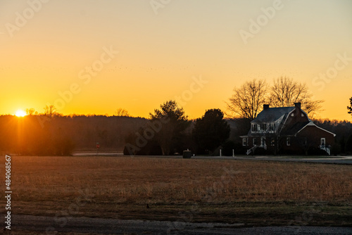 Sunset over a farm field in a rural neighborhood photo