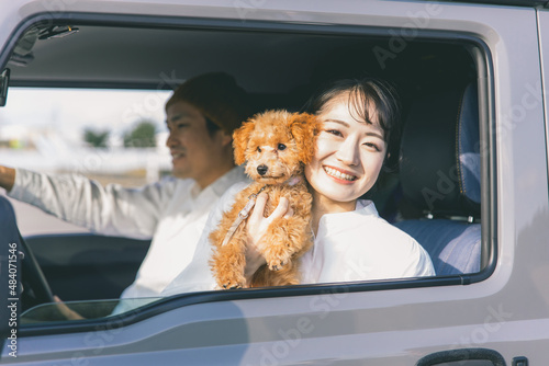 車でお出かけする犬と男女（車内）  © buritora
