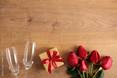 red rose flowers and gift box on wooden background