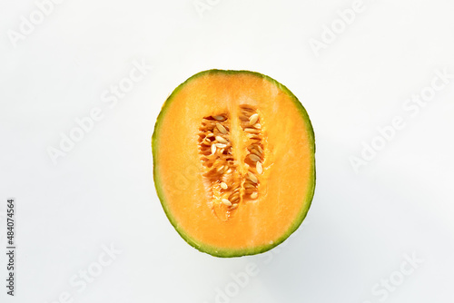 Top down view of a cross section of a cantaloupe isolated against white.