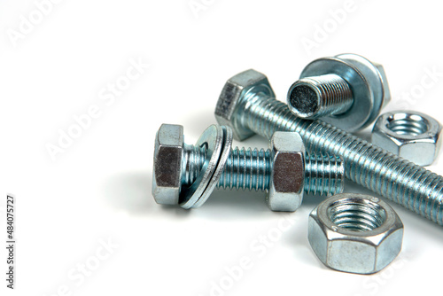 фотографія several metal washers, nuts and bolts of silver color on a white background