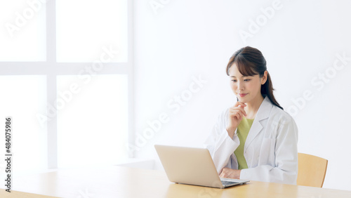 パソコンを見る白衣の女性