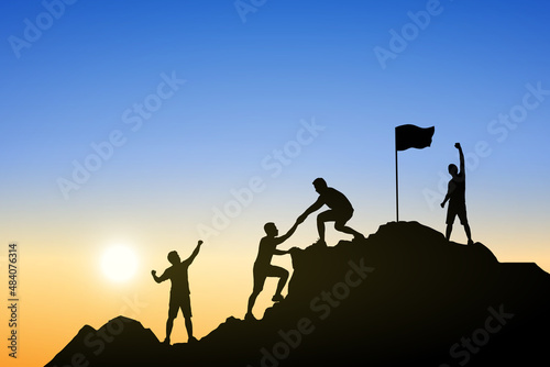 Silhouette of people helping each other hike up a mountain at sunrise. Business, teamwork, goal, success and help concept.