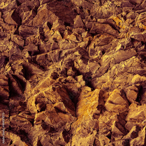Yellow orange red brown stone texture. Mountains surface. Close-up. Сrushed stone background with space for design. Bright. Rocky background. 3D shape.