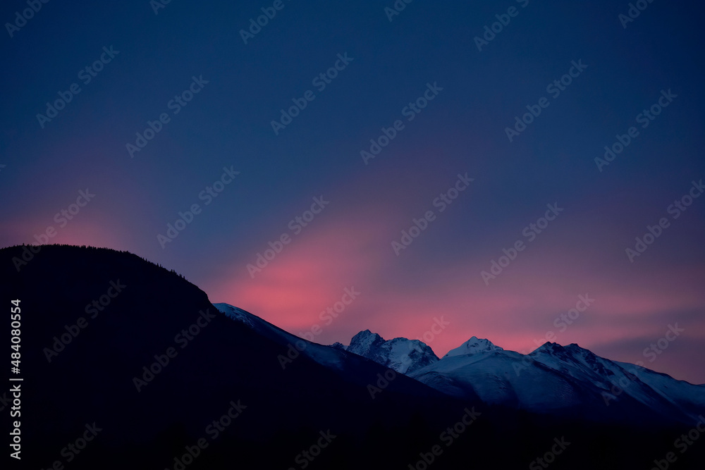 Sunrise colors the morning sky over Alaska's Chugach Range. 