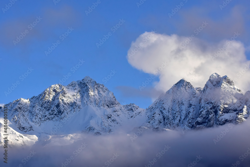 Clouds over snow-covered mountains in winter.