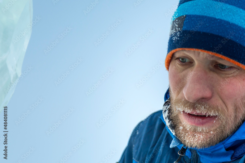 Portrait of a builder in a blue knitted hat and blue winter jacket Portrait of a builder in a blue knitted hat and blue winter jacket