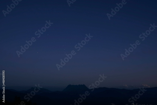 Orion constellation on twilight sky over a mountain silhouette in a sunset time