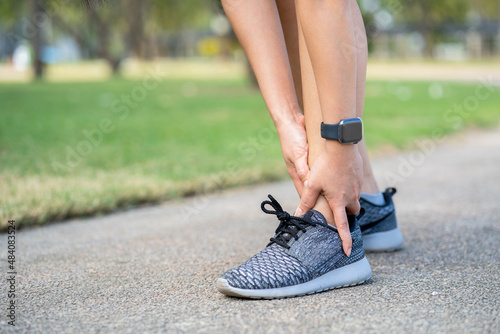 Young woman asian have accident ankle twist sprain in sport exercise jogging, selective focus photo