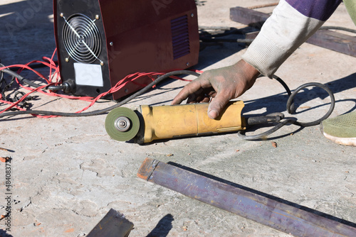 Metal cutting handheld machine with a cutting disc. Construction works. Hand Tools.