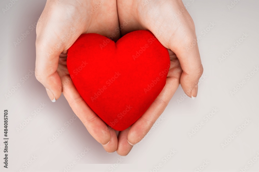 Person holding white heart in palm. Organ donation and insurance concept.