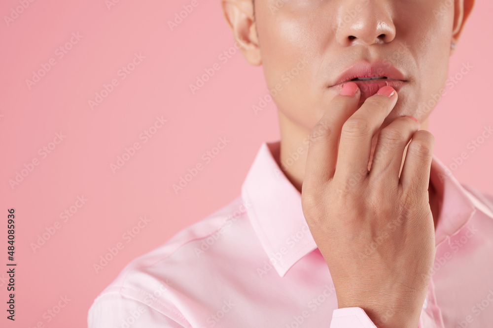 Cropped image of young man touching his full lips with manicured hand Cropped image of young man touching his full lips with manicured hand