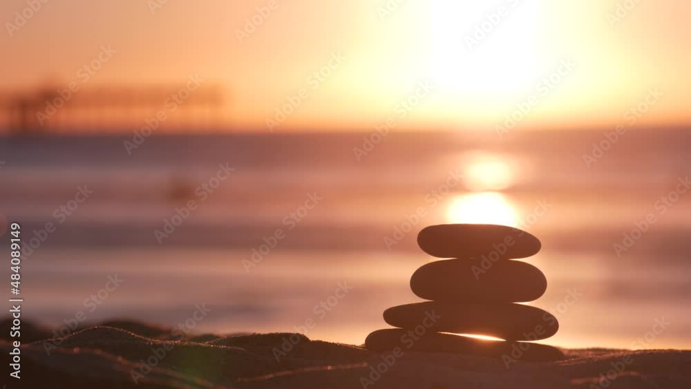 Stack of pebble stones, sandy ocean beach, sunset sky. Rock balancing in sun light, sea water waves. Stones staking in pyramid pile. Zen meditation and harmony in balance. Seamless looped cinemagraph. Stack of pebble stones, sandy ocean beach, sunset sky. Rock balancing in sun light, sea water waves. Stones staking in pyramid pile. Zen meditation and harmony in balance. Seamless looped cinemagraph.