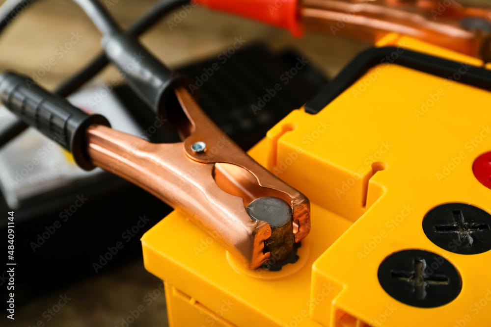 Modern car battery and tester on table, closeup Modern car battery and tester on table, closeup