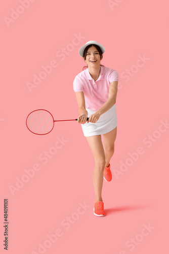 Sporty female badminton player on color background © Pixel-Shot