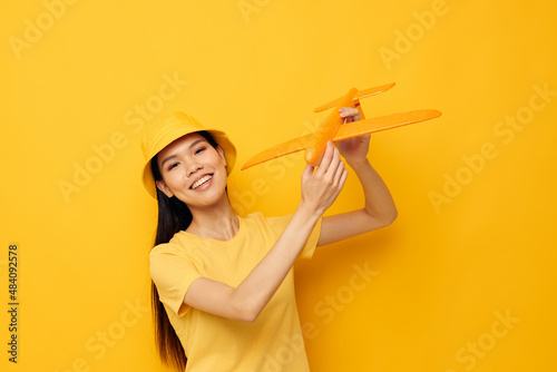 Portrait Asian beautiful young woman cheerful woman with an airplane in the hands of fun isolated background unaltered