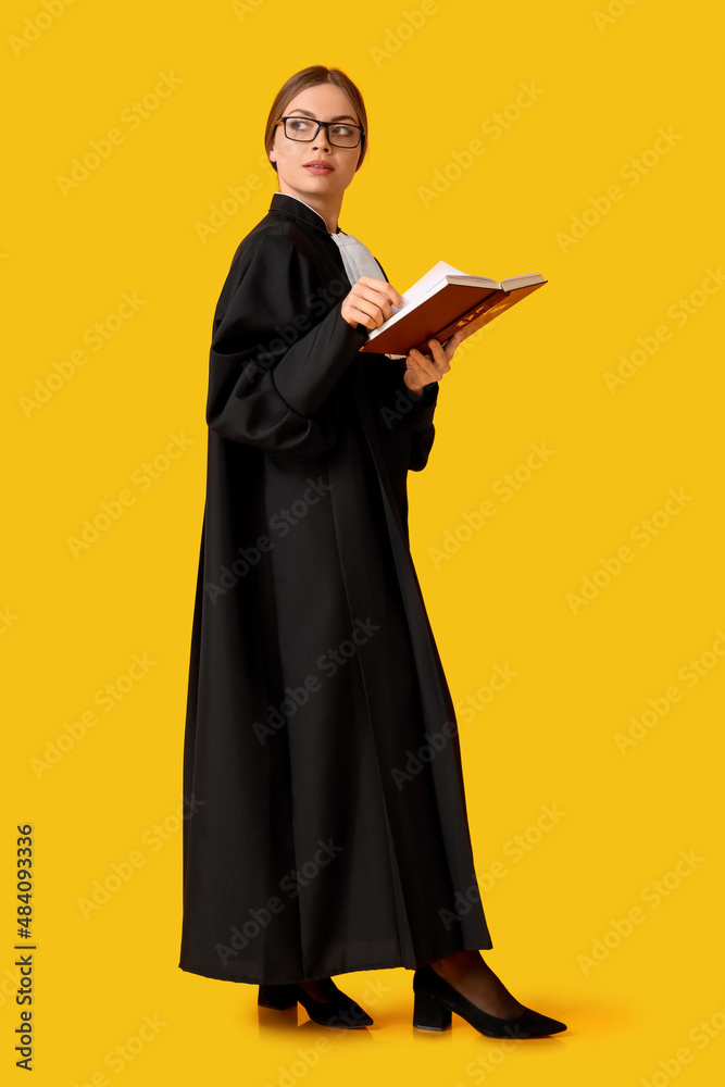 Young female judge with book on color background Young female judge with book on color background