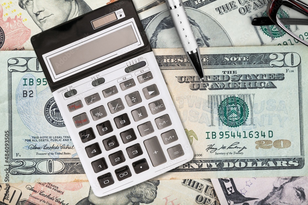 Fototapeta premium Money banknotes on a wooden table with a calculator Economics and financial planning