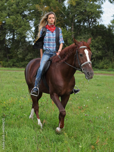 Beautiful cowgirl ride horseback in autumn forest 