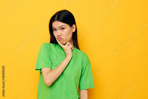 woman in green t-shirts gestures with his hands emotions studio model unaltered