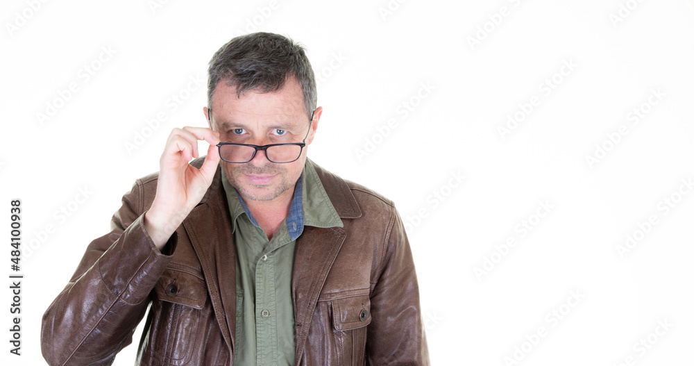 handsome man in leather jacket with his hand on the arm of his glasses next to a white empty space handsome man in leather jacket with his hand on the arm of his glasses next to a white empty space